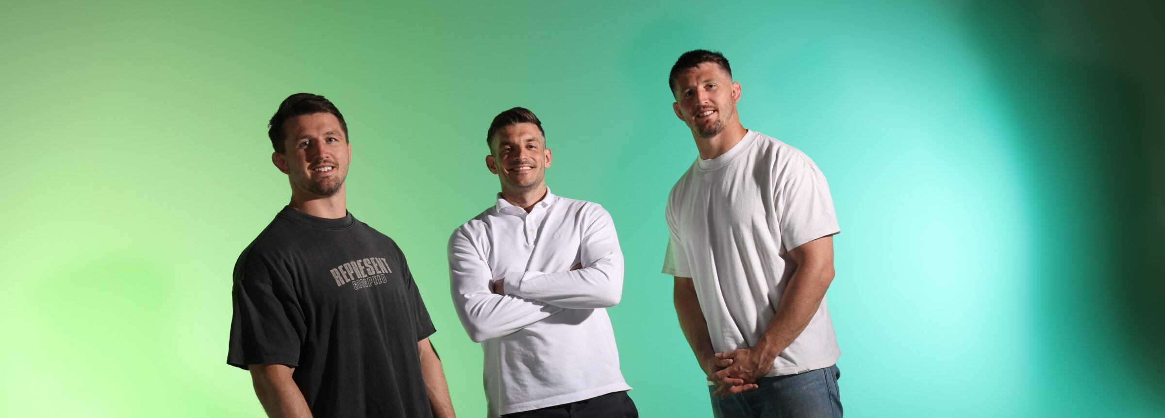 Hero — three athletes standing, studio green backdrop
