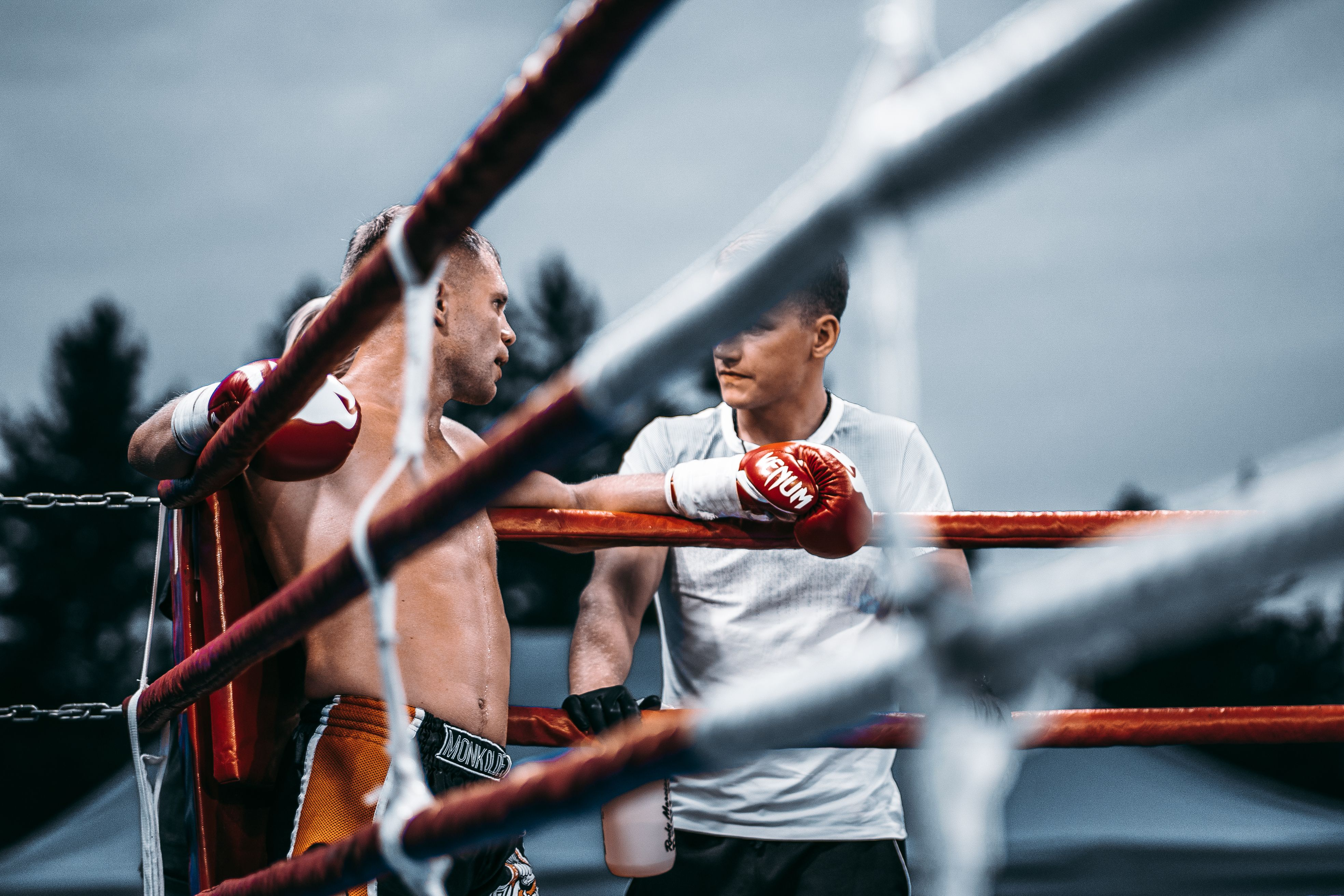 Boxer in the ring with coach, gloves up