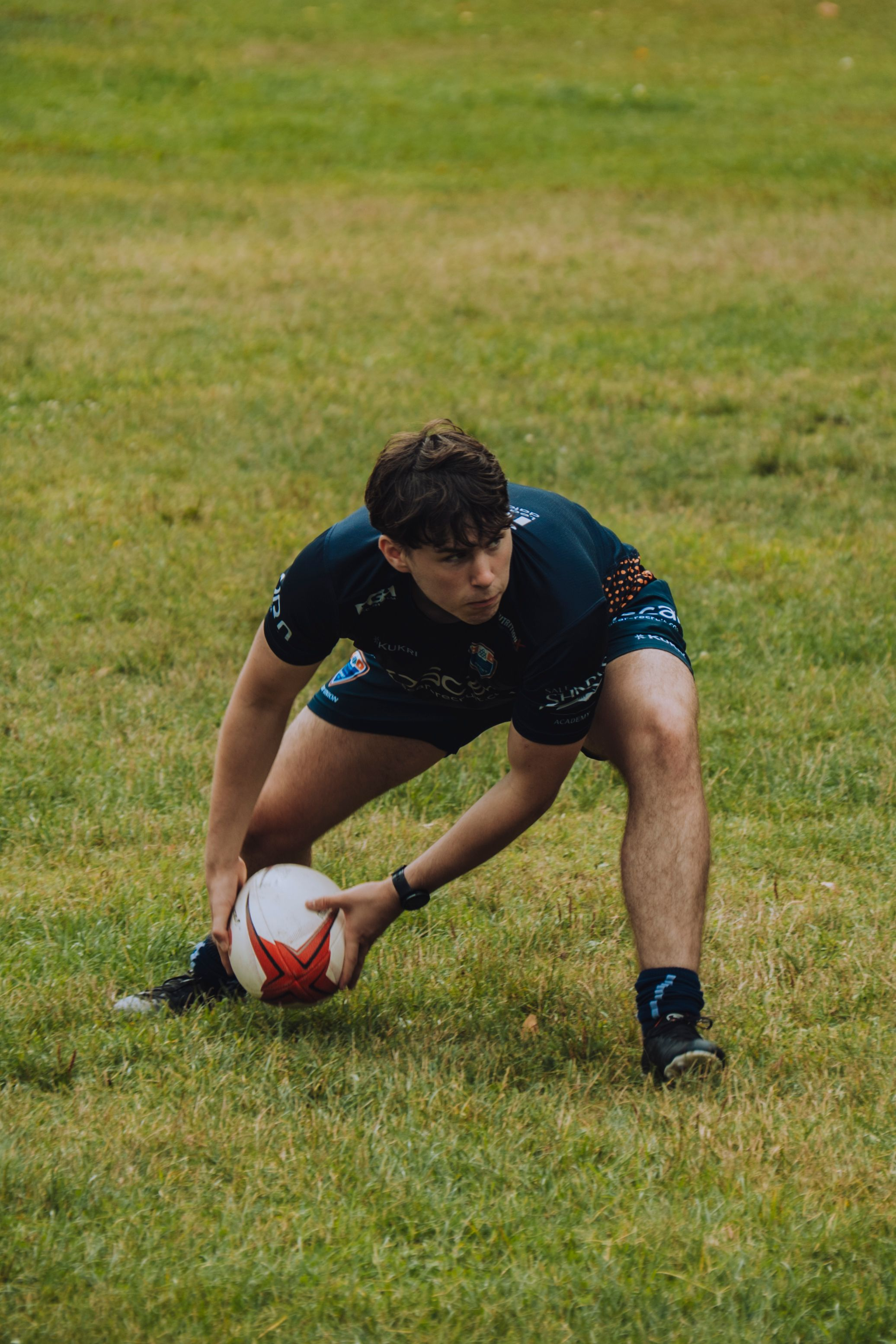 Hero — rugby player placing the ball for a kick, low angle