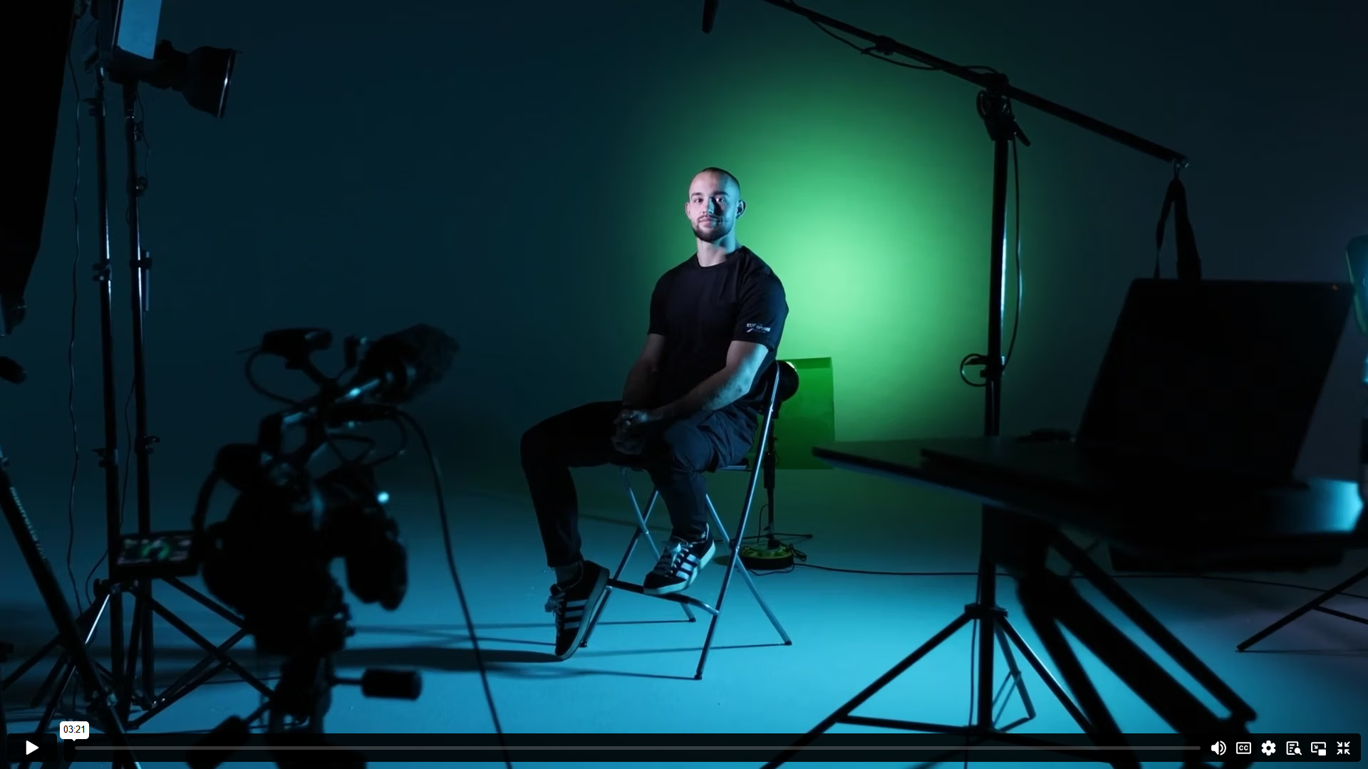 Video still — Ross Cullen seated on set, green studio lighting
