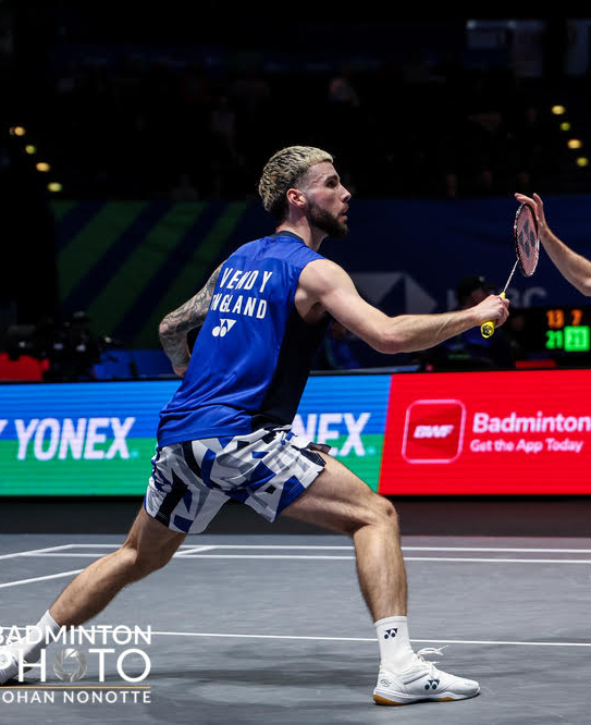 Hero — badminton player mid-shot, England kit