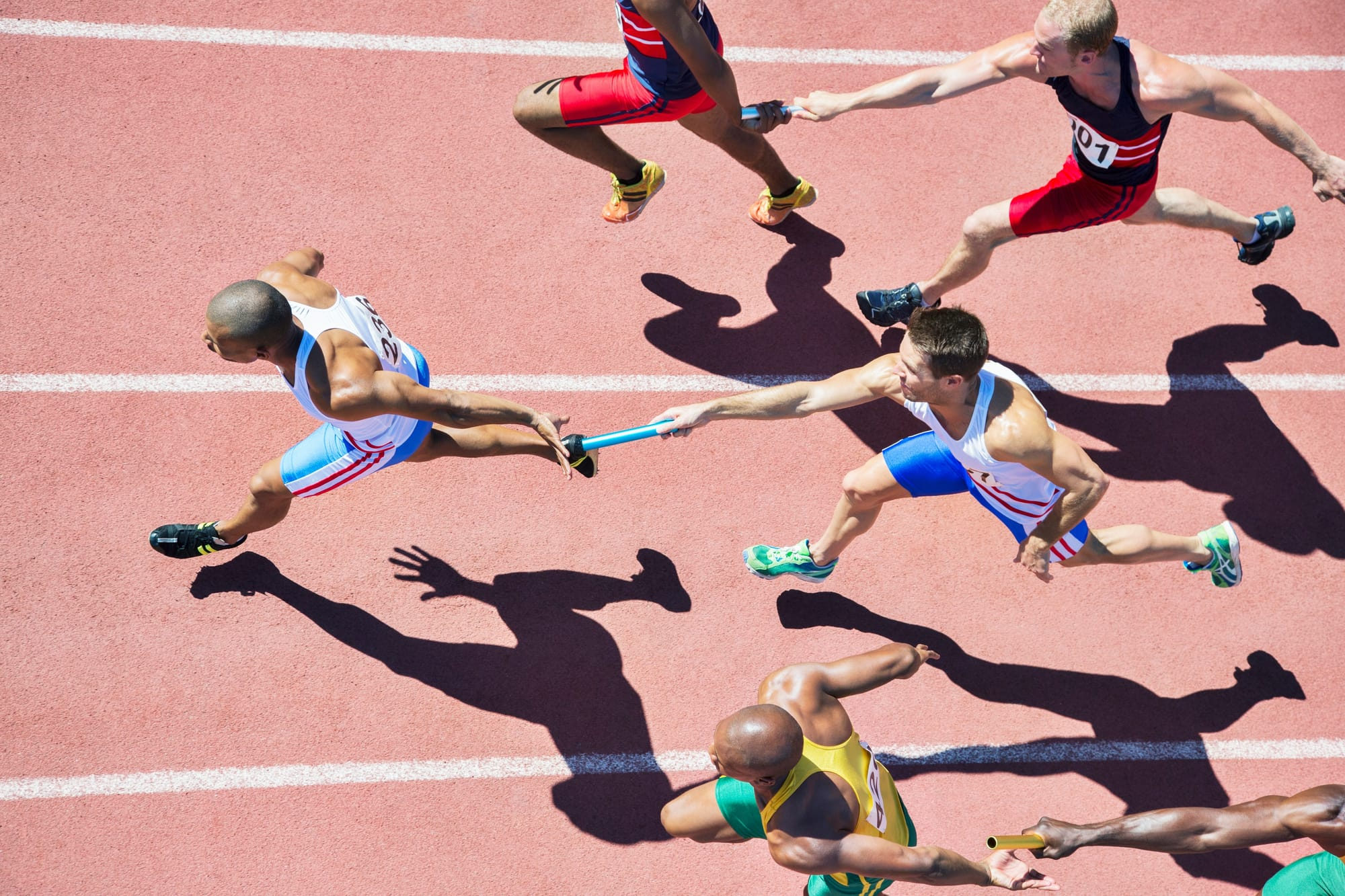 Sprinters on track from above, long shadows
