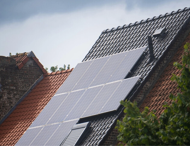 Solar panels installed on a pitched residential roof generating renewable energy in a suburban setting