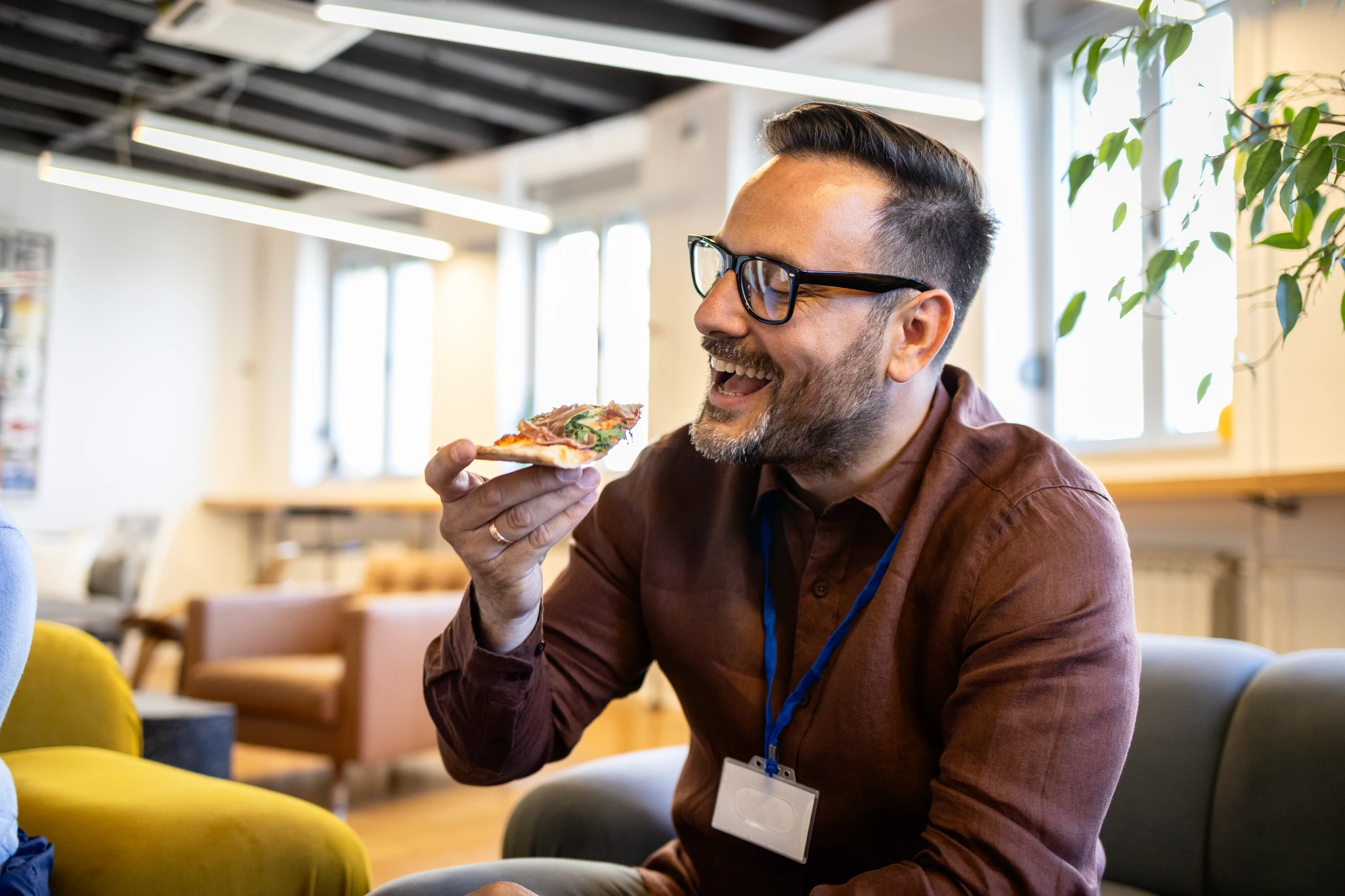 A colleague laughing over a slice of pizza in the office