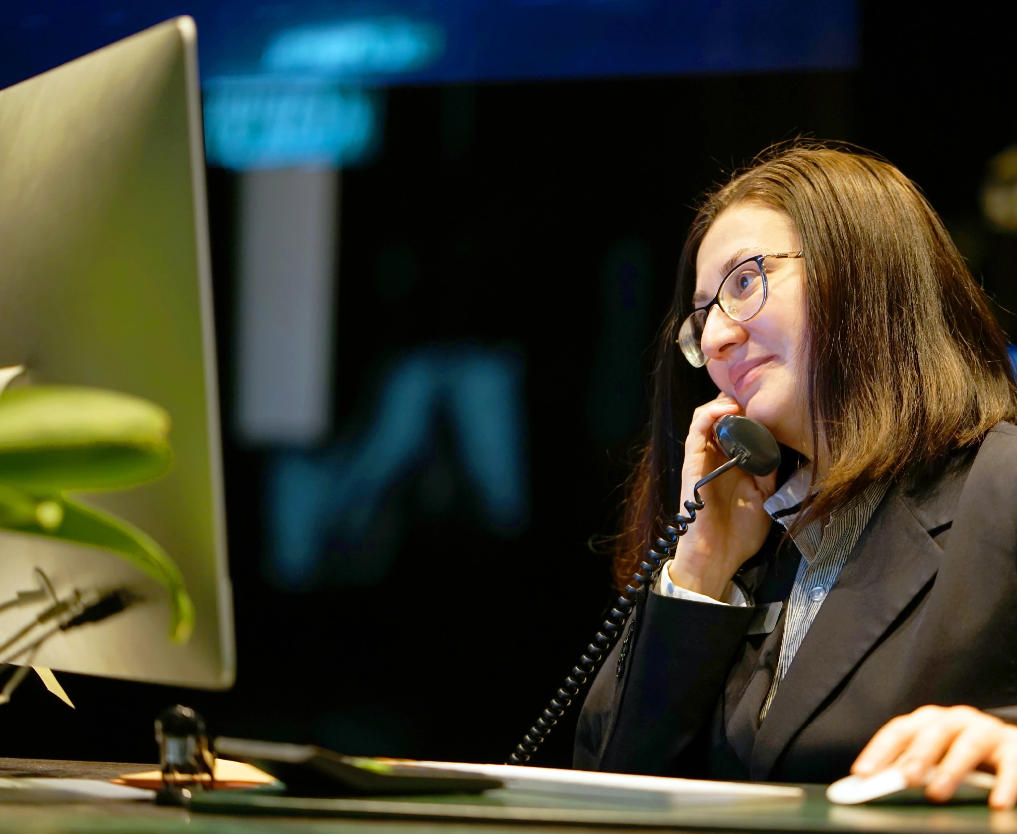 Two colleagues talking across a desk in the Tenos office