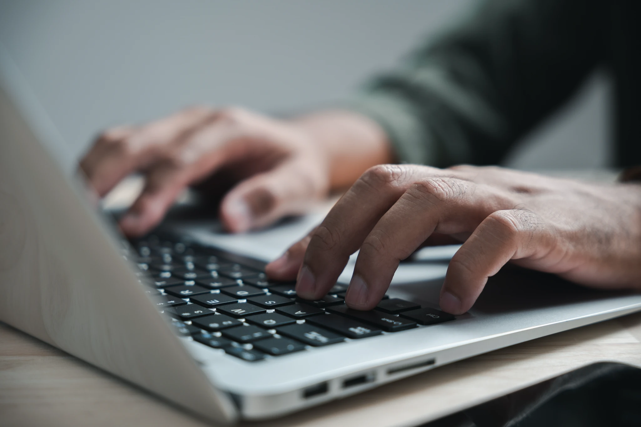Close view of hands typing on a laptop keyboard