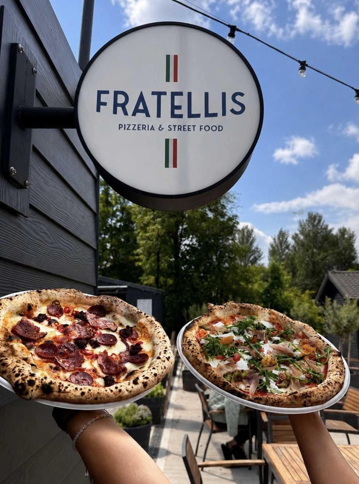 Fratellis pizzas in front of the sign