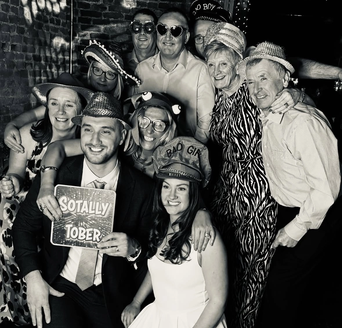 A group of wedding guests posing with props